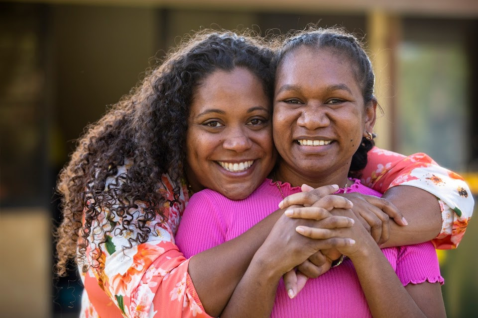 Two Aboriginal women, smiling.