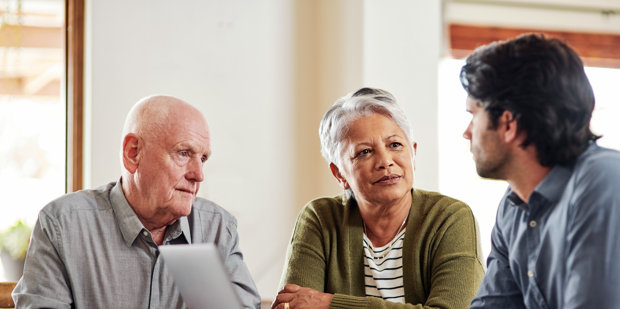 Elderly couple sitting at a table speaking with a funeral planner