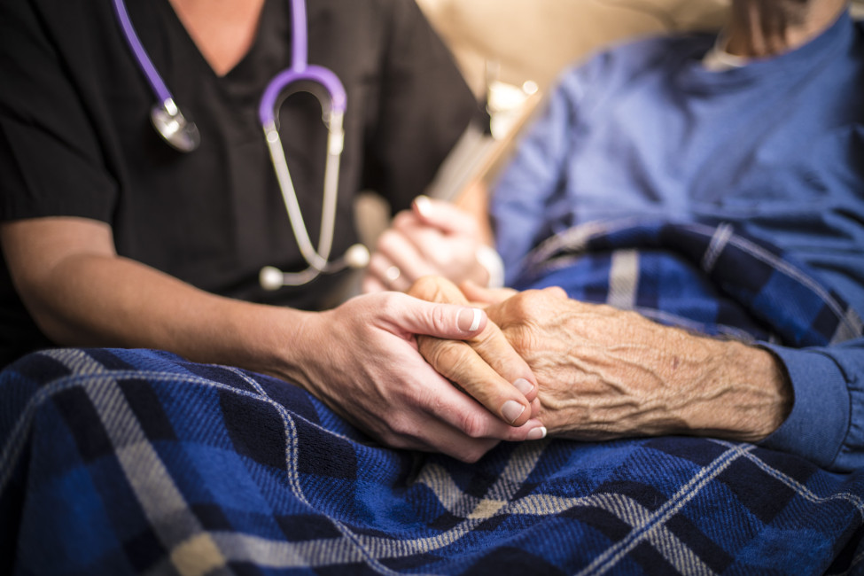 Nurse comforting an elderly patient.