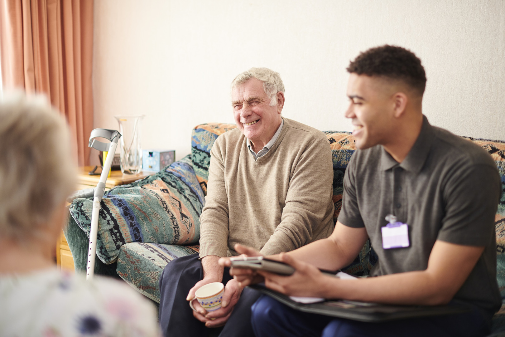 Support worker talking to elderly man.
