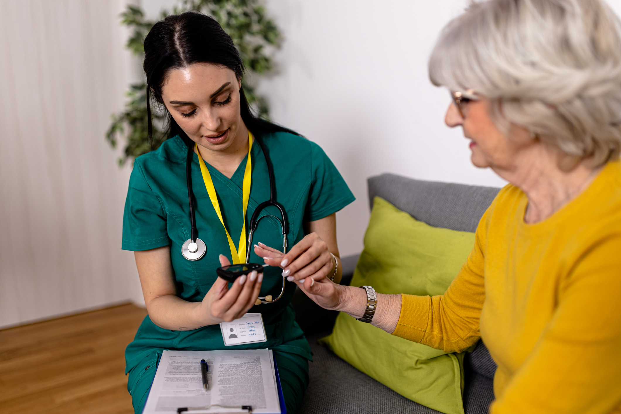 Nurse sitting with a patient taking their blood pressure