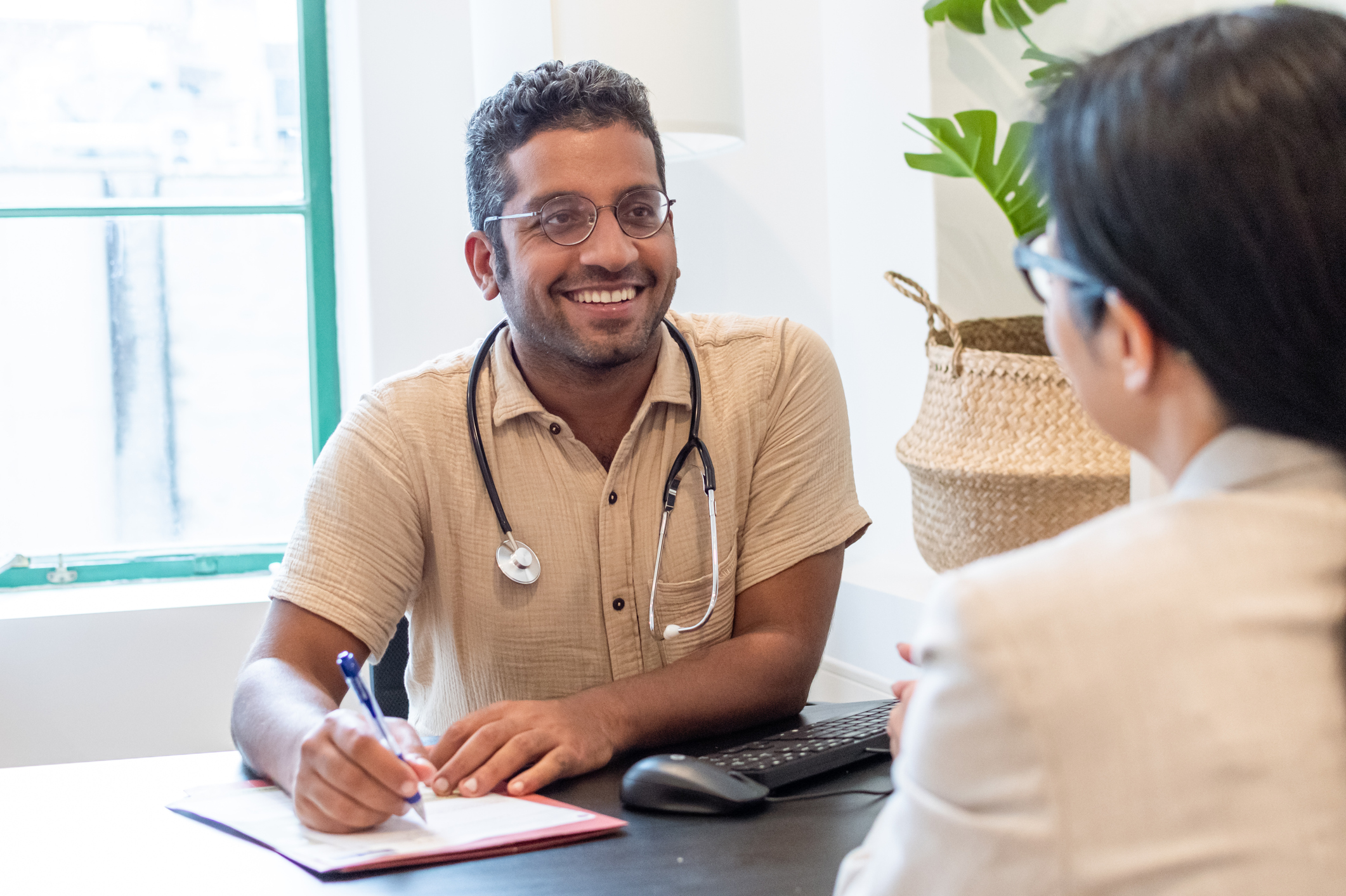 GP speaking with a patient at their desk