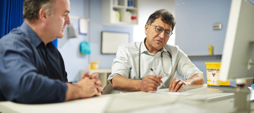 Doctor writing script for male patient.