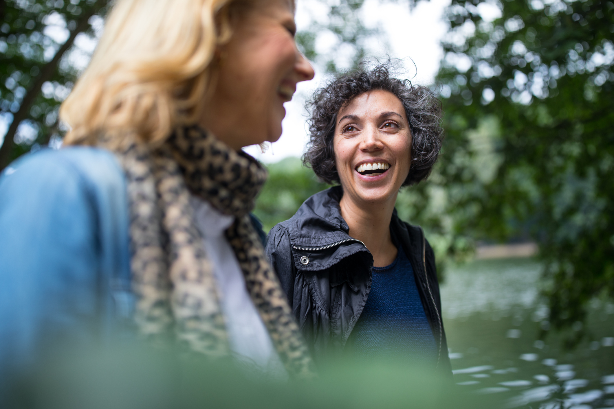 Two women walking outside smiling and talking