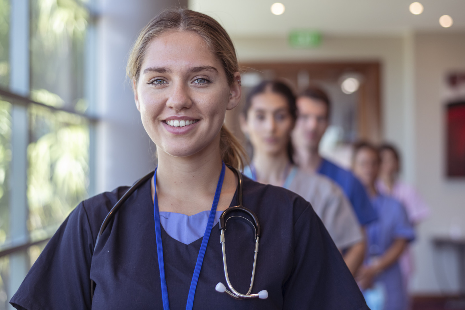 Female nurse standing in front of other nurses in the background