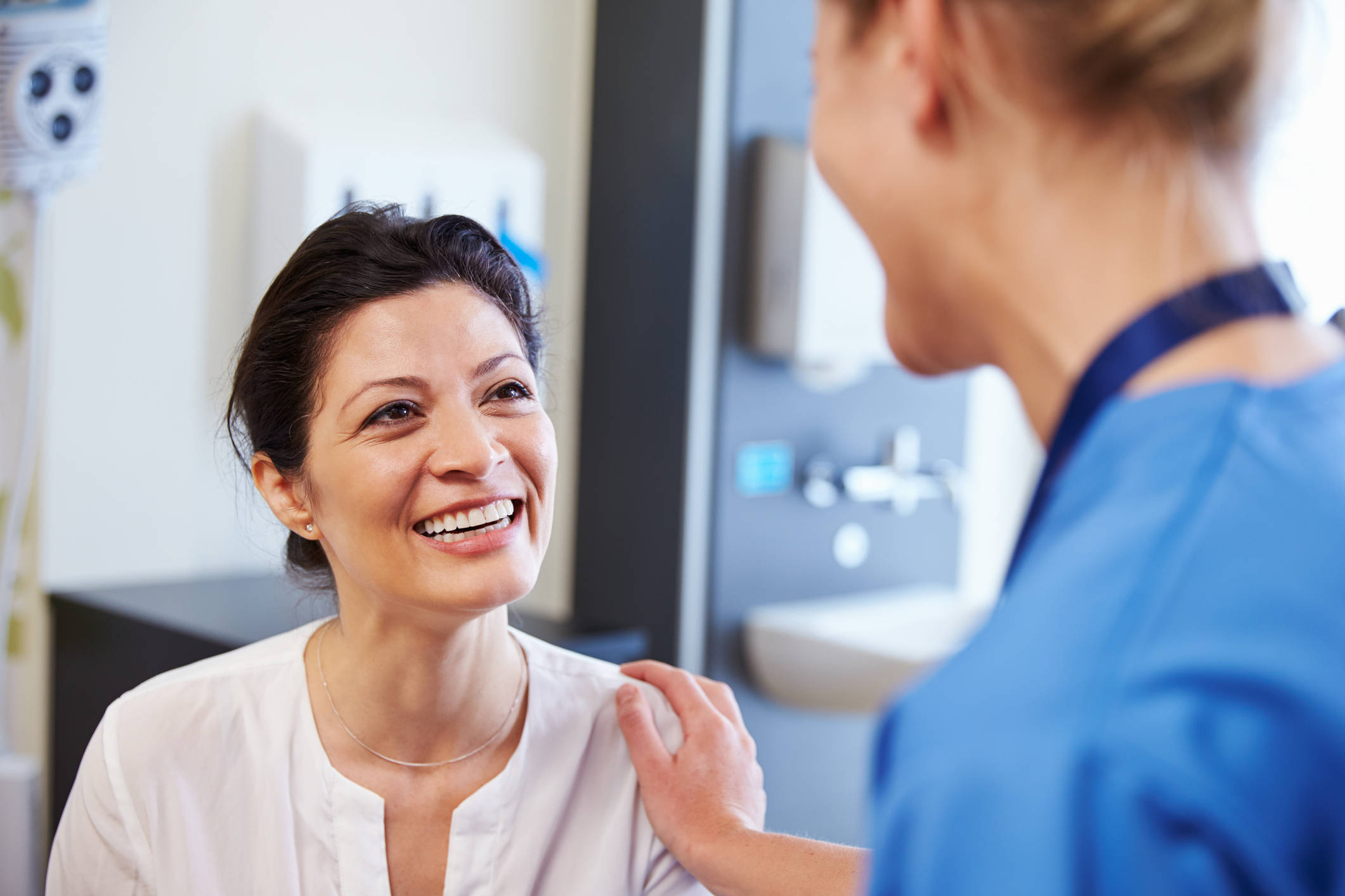 Female G P speaking with a patient in a medical setting